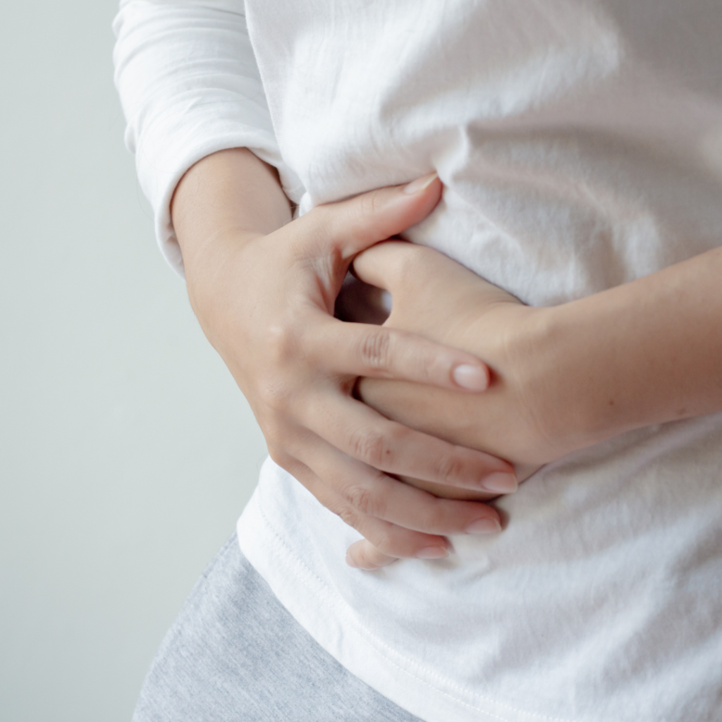 Picture of lady holding her belly, due to common cause of bloating paint.